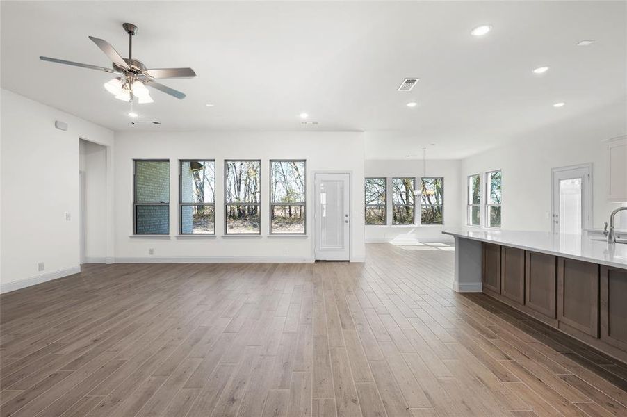 Unfurnished living room with recessed lighting, light wood-style floors, and a ceiling fan Unfurnished living room with recessed lighting, light wood-style floors, and a ceiling fan