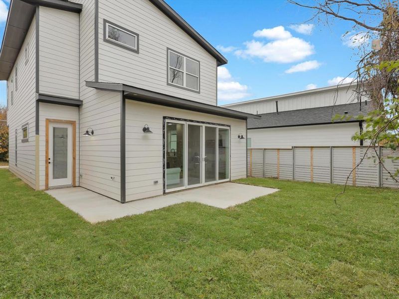 Back of house with a yard and a patio