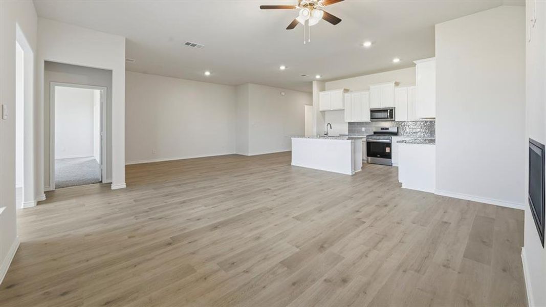 Unfurnished living room with light wood finished floors, ceiling fan, and recessed lighting