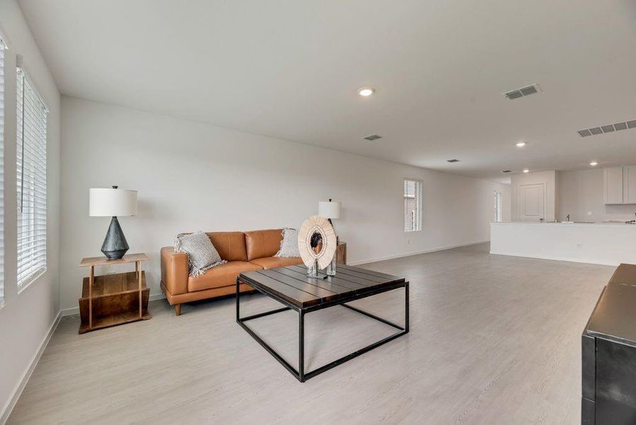 Living area with light wood-style floors and recessed lighting