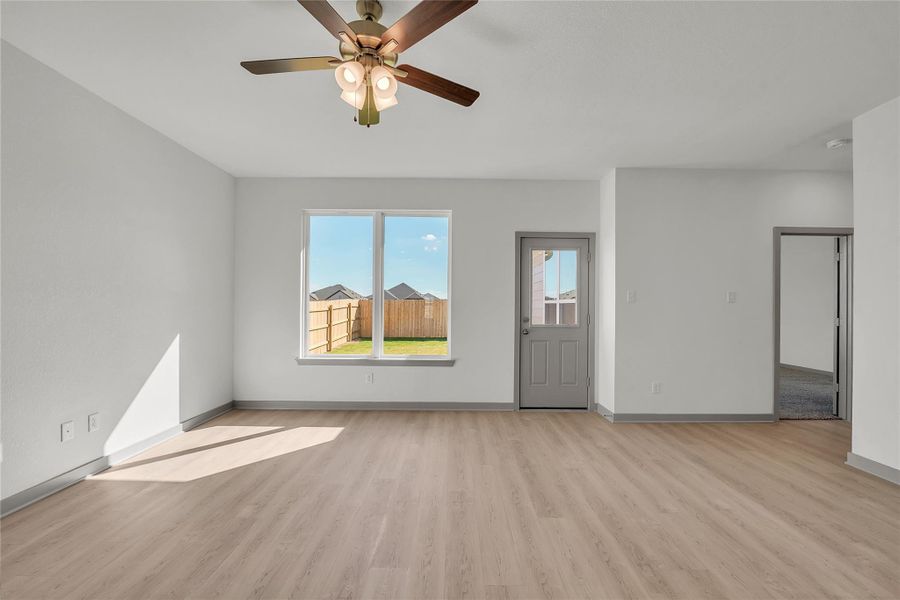 Unfurnished living room with light wood-type flooring and ceiling fan