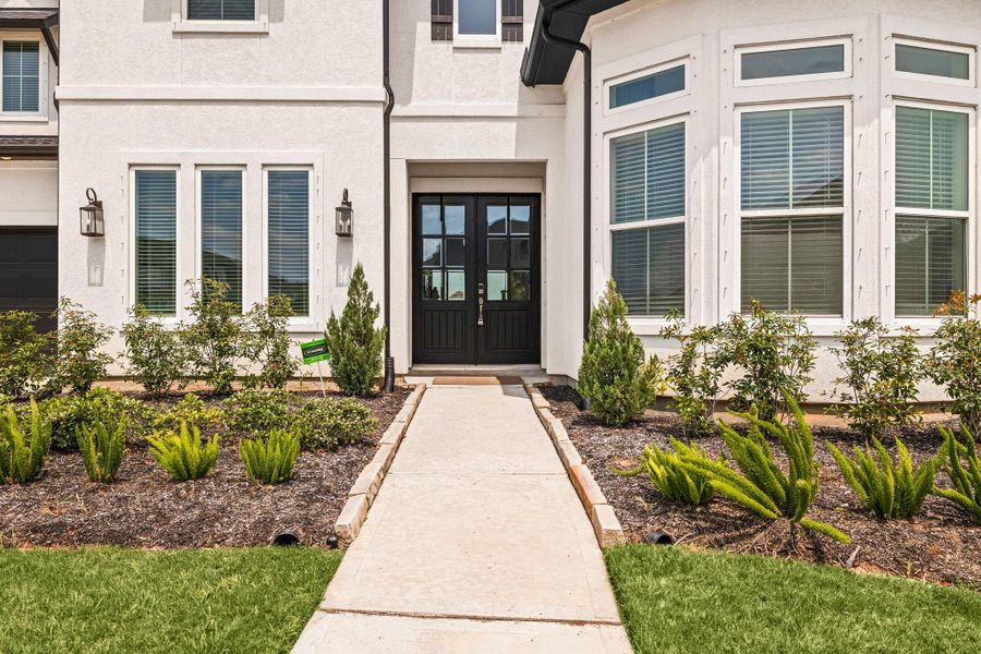 Beautiful front entry with clean landscaping and a welcoming approach to the home.