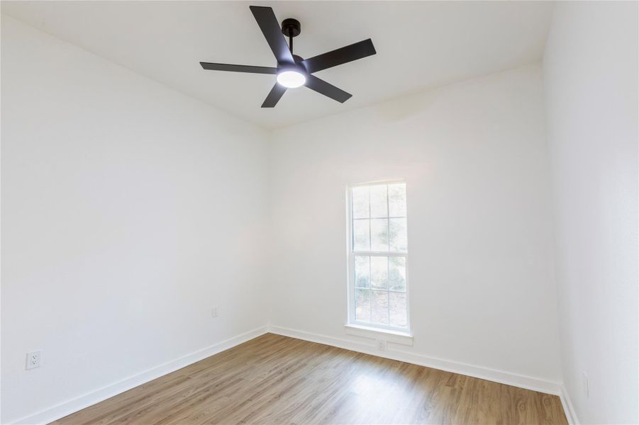 Secondary bedroom featuring large window and abundant sunlight.