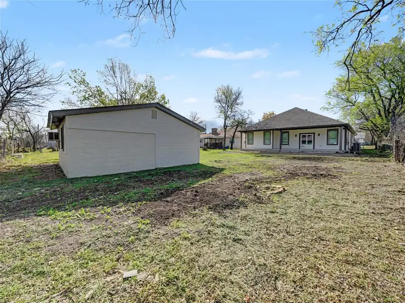 Rear view of property featuring an outdoor structure, a yard, and a patio