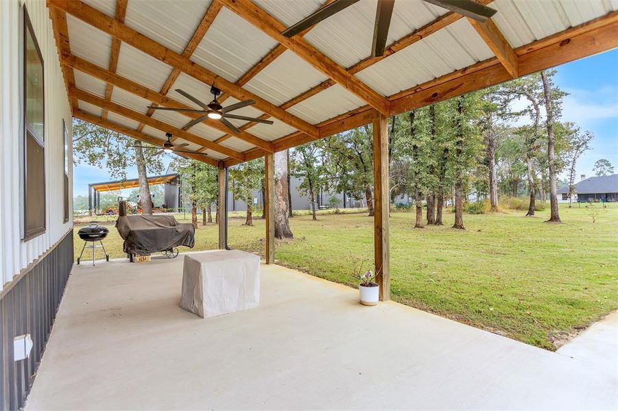 Separate metal workshop accented by covered patio featuring ceiling fans and wood accents. Separate metal workshop accented by covered patio featuring ceiling fans and wood accents.