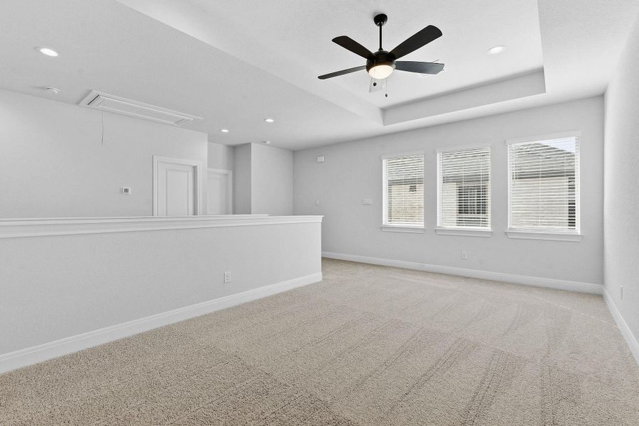 Unfurnished room with a ceiling fan, light carpet, recessed lighting, and a raised ceiling