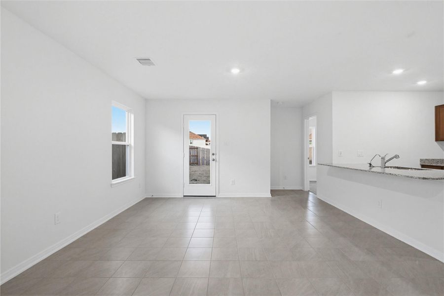Create lasting memories around the table with family and friends in this inviting dining room! It showcases high ceilings, large window, tile flooring, recessed lighting, and access door to the backyard. Additionally, there is extra seating with the added breakfast bar to the kitchen granite countertop.