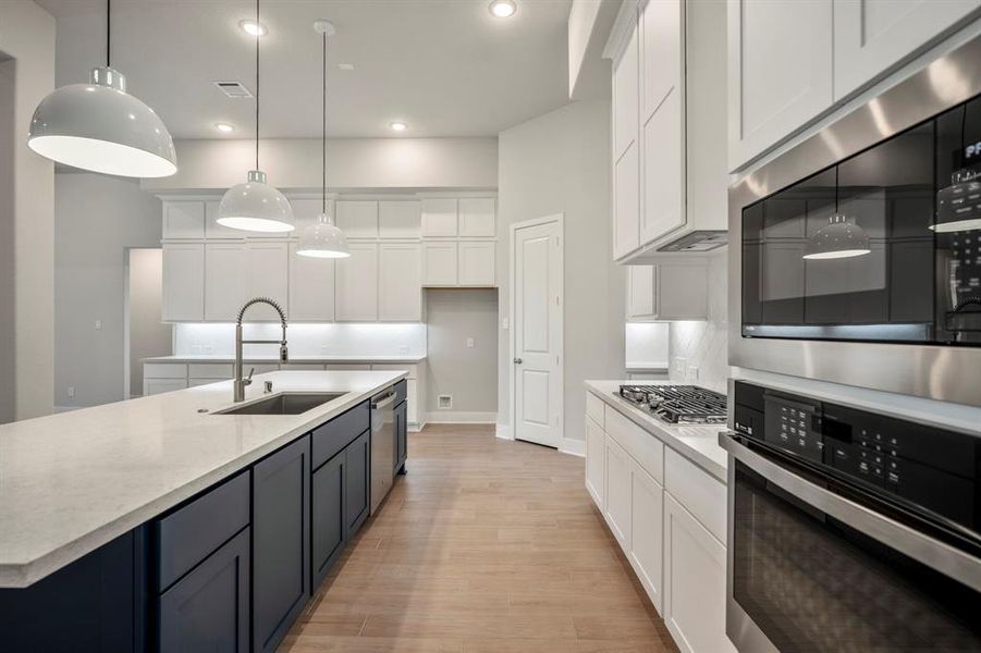 The expansive quartz island invites gatherings, while sleek GE stainless steel appliances make mealtime a breeze.