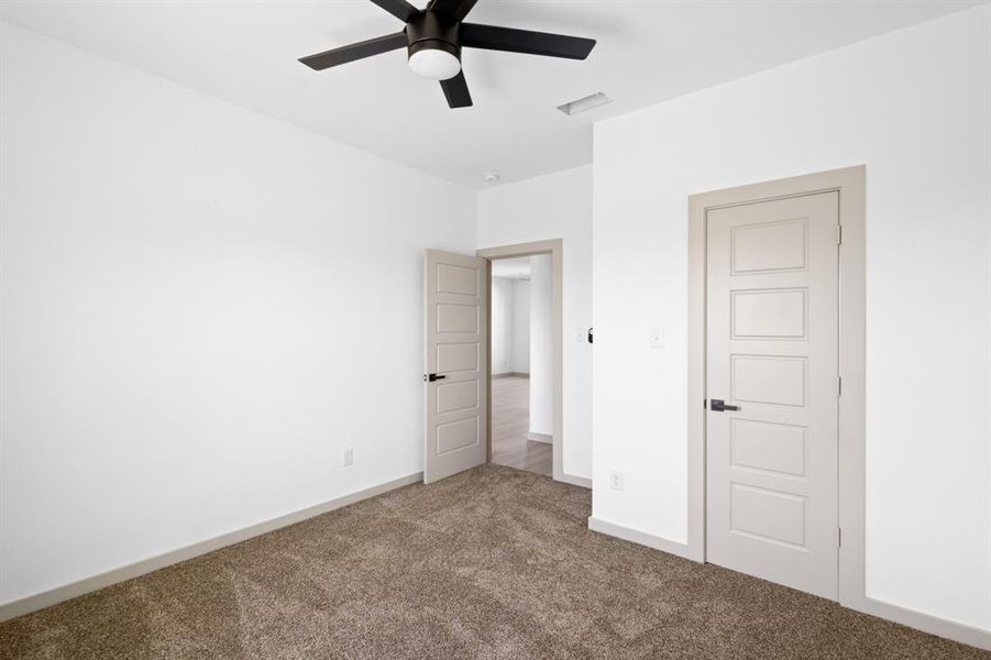 Unfurnished bedroom with carpet floors, a ceiling fan, visible vents, and baseboards Unfurnished bedroom with carpet floors, a ceiling fan, visible vents, and baseboards