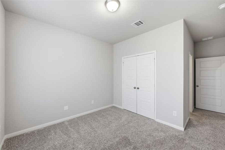 Unfurnished bedroom featuring carpet and a closet