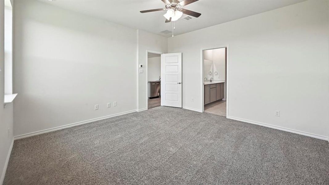 Spacious room featuring gray carpet flooring and white walls