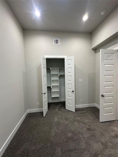 Unfurnished bedroom with a closet and dark colored carpet