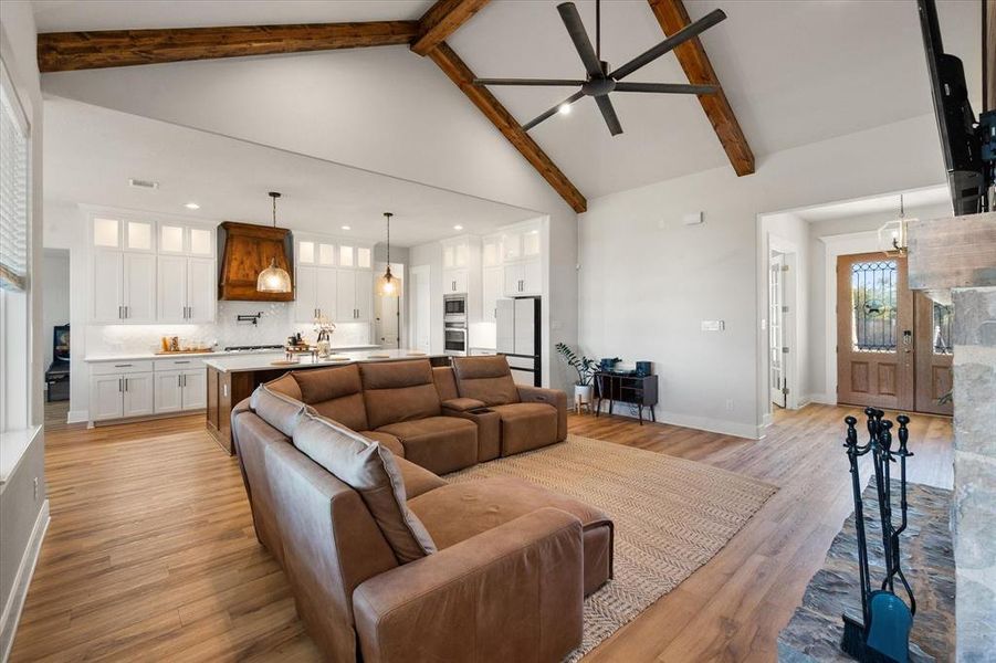 Living area featuring high vaulted ceiling, light wood-type flooring, beam ceiling, ceiling fan, and recessed lighting