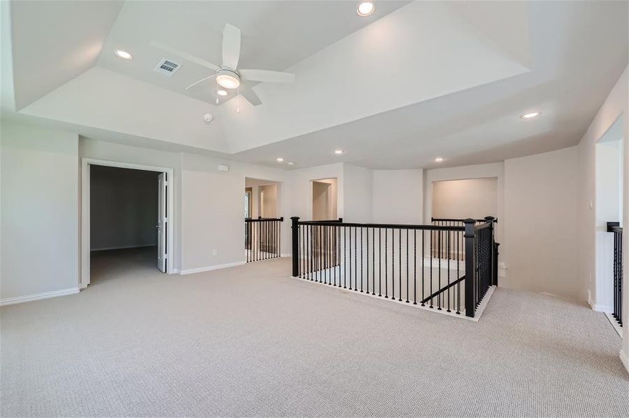 Bonus room featuring light colored carpet and ceiling fan