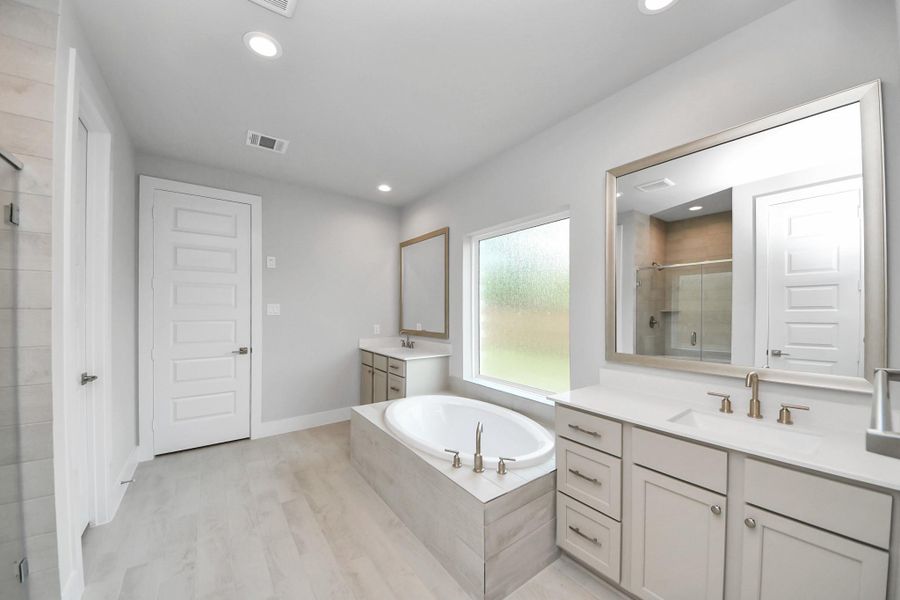 Indulge in the serenity of your primary bathroom, a true retreat designed for relaxation. The spacious walk-in shower, encased in elegant tile, invites you to unwind, while the separate garden tub, featuring unique, custom details, offers a perfect place for soaking away the day's stresses. Indulge in the serenity of your primary bathroom, a true retreat designed for relaxation. The spacious walk-in shower, encased in elegant tile, invites you to unwind, while the separate garden tub, featuring unique, custom details, offers a perfect place for soaking away the day's stresses.