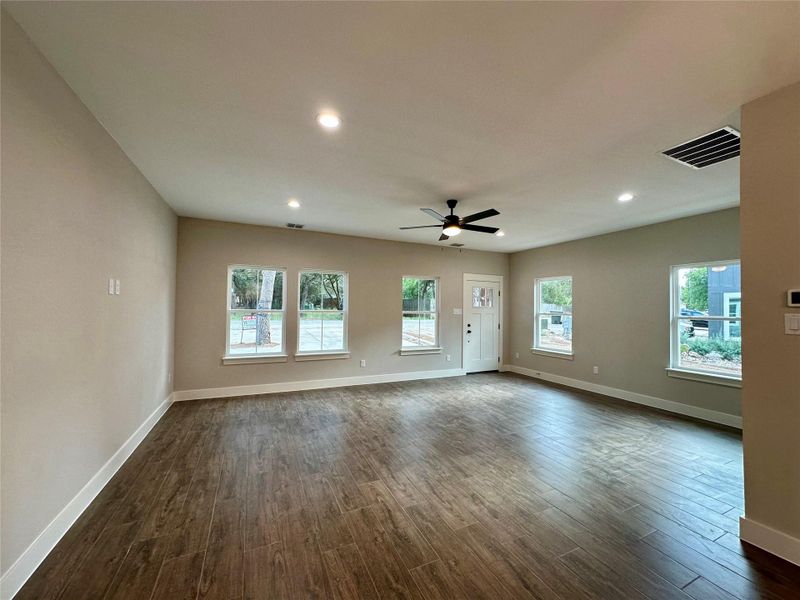 Unfurnished living room with recessed lighting, healthy amount of natural light, dark wood-type flooring, and ceiling fan