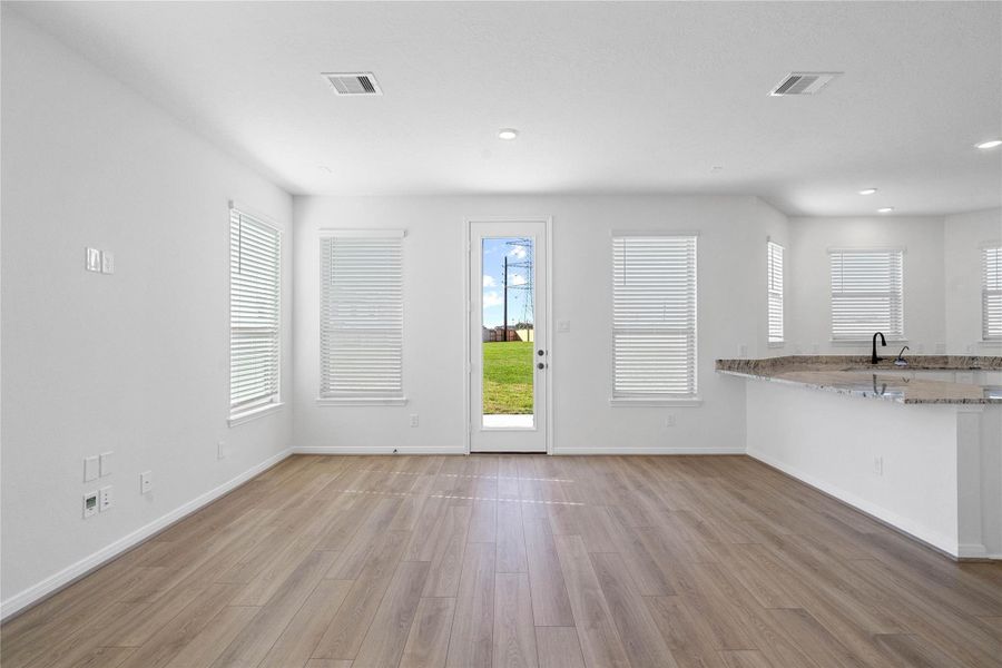 Create lasting memories around the table with family and friends in this inviting dining room! It showcases high ceilings, large windows with privacy blinds, access door to the back patio and yard, vinyl plank flooring, and recessed lighting for a warm and welcoming atmosphere. Create lasting memories around the table with family and friends in this inviting dining room! It showcases high ceilings, large windows with privacy blinds, access door to the back patio and yard, vinyl plank flooring, and recessed lighting for a warm and welcoming atmosphere.