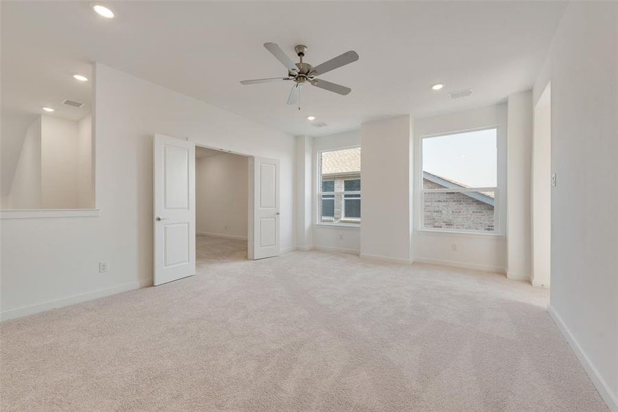 Carpeted spare room featuring ceiling fan