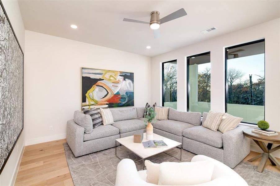 Living room with light wood-type flooring and ceiling fan