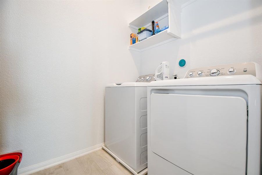 The utility room features built-in shelving for convenient household storage and is located near the kitchen for easy access.