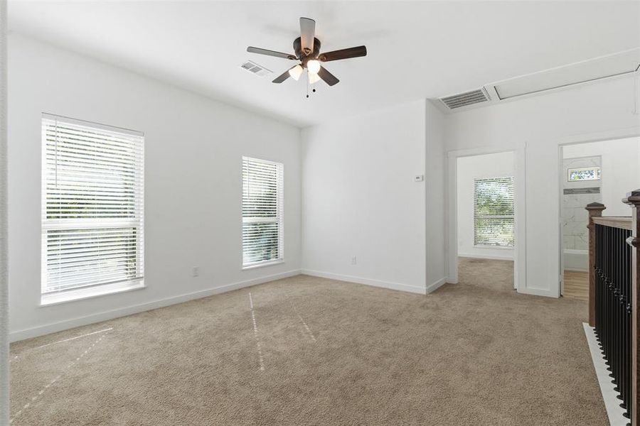 Unfurnished bedroom featuring carpet flooring, a ceiling fan, and attic access Unfurnished bedroom featuring carpet flooring, a ceiling fan, and attic access