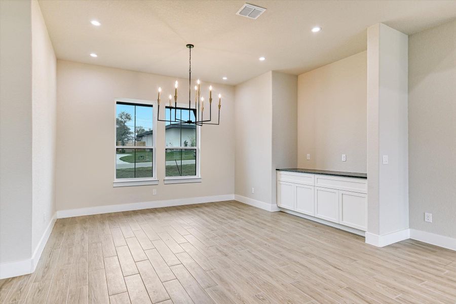 Unfurnished dining area with light wood-style flooring and a chandelier