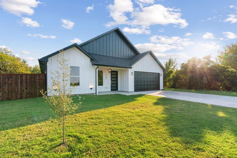 Modern farmhouse style home featuring a garage and a front lawn