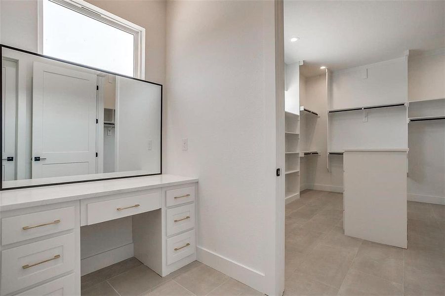 Bathroom featuring tile patterned flooring, vanity, a spacious closet, baseboards, and recessed lighting Bathroom featuring tile patterned flooring, vanity, a spacious closet, baseboards, and recessed lighting