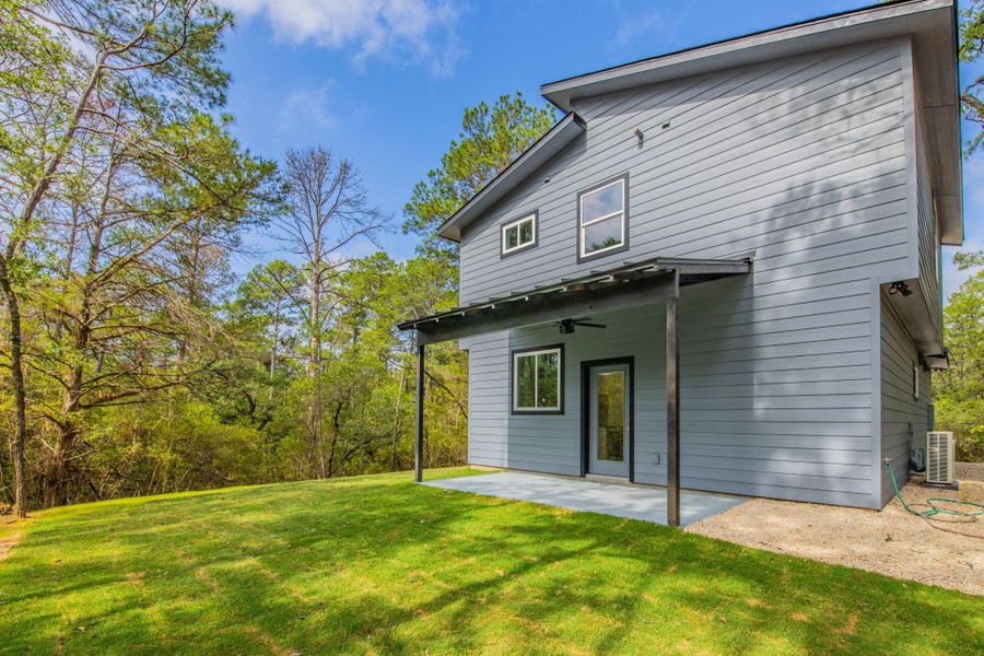 Gray siding exterior featuring a covered patio, ceiling fan, and black-framed windows Gray siding exterior featuring a covered patio, ceiling fan, and black-framed windows