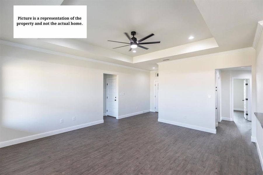 Spacious interior featuring wood-finish flooring, a tray ceiling with a ceiling fan, recessed lighting, and white trim throughout