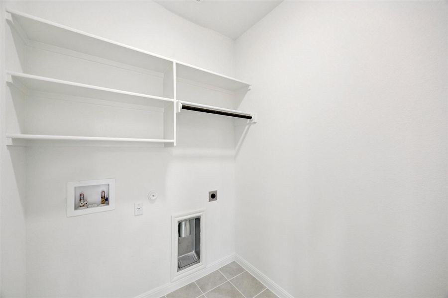 Laundry area featuring hookup for a gas dryer, light tile patterned floors, hookup for a washing machine, and electric dryer hookup Laundry area featuring hookup for a gas dryer, light tile patterned floors, hookup for a washing machine, and electric dryer hookup