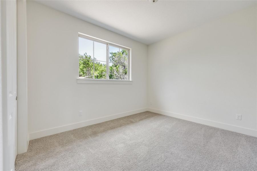 Carpeted spare room with baseboards