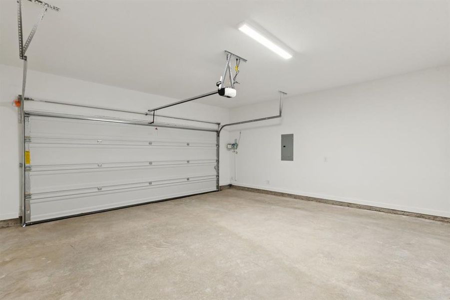 Garage featuring electric panel and a garage door opener Garage featuring electric panel and a garage door opener