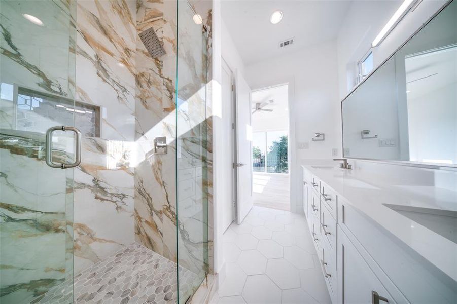 Bathroom with a shower with door, ceiling fan, tile patterned flooring, and vanity