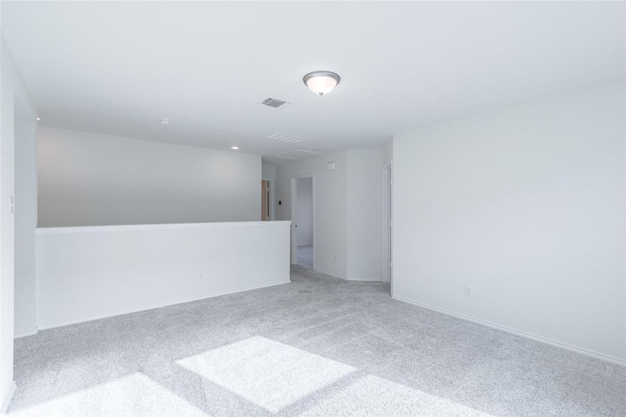 A spacious secondary living area features soft carpeting and ample overhead lighting. A spacious secondary living area features soft carpeting and ample overhead lighting.