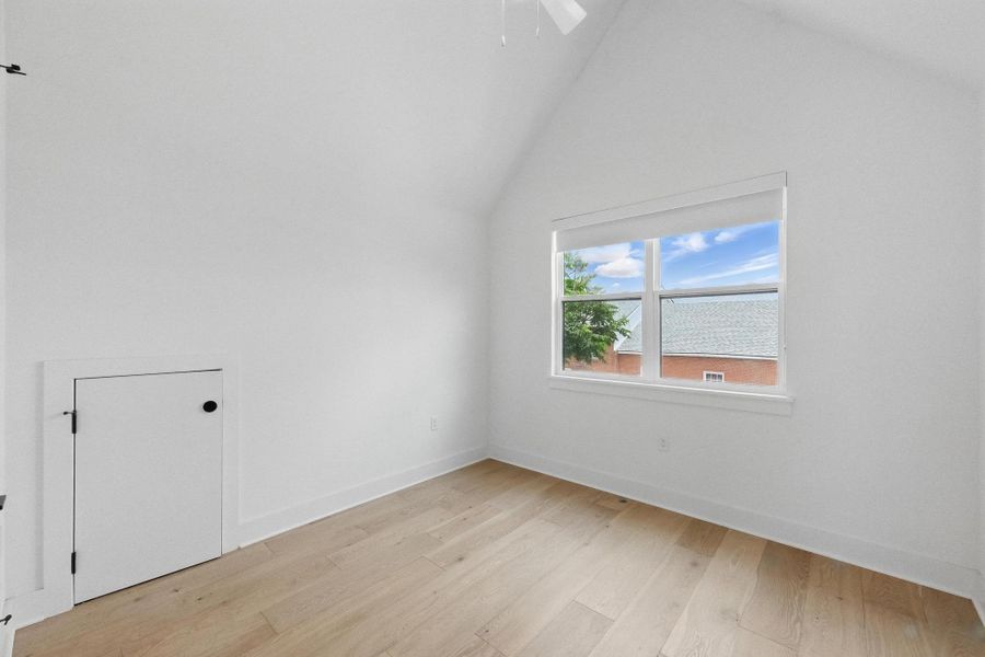Bonus room featuring light wood-style flooring and high vaulted ceiling Bonus room featuring light wood-style flooring and high vaulted ceiling