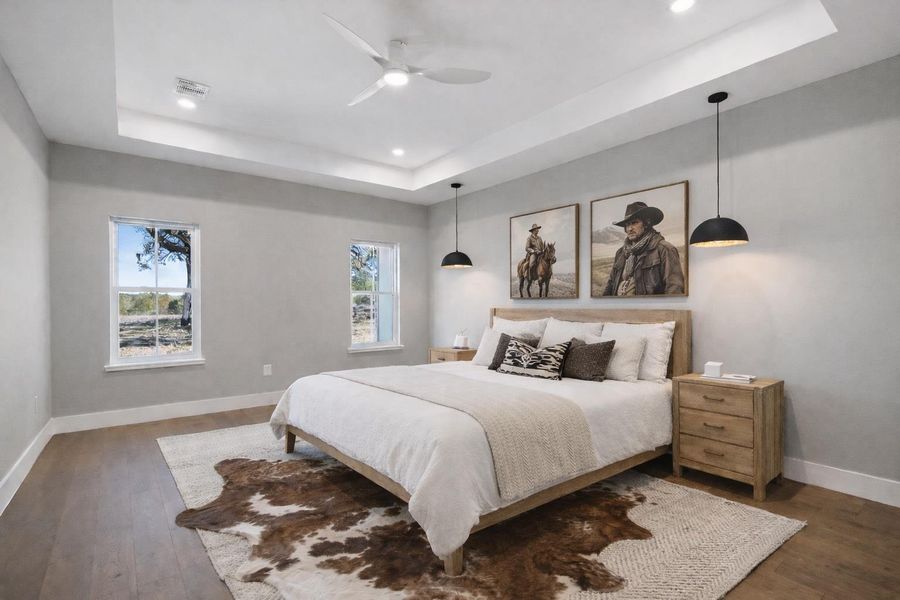 Bedroom with a tray ceiling, hardwood / wood-style flooring, a ceiling fan, and recessed lighting
