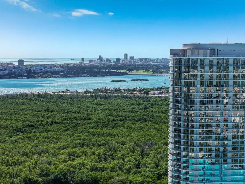 High-rise residential tower featuring floor-to-ceiling glass windows, wrap-around private balconies, and an exterior facade of glass and steel