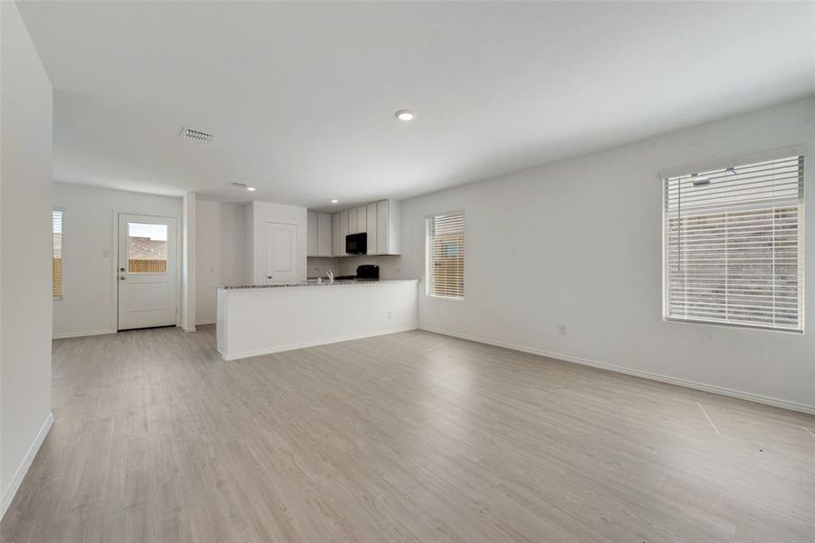 Unfurnished living room with light hardwood / wood-style flooring and plenty of natural light