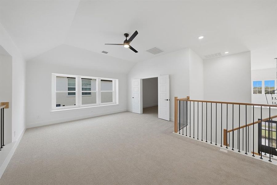 Empty room with carpet flooring, vaulted ceiling, a ceiling fan, and recessed lighting Empty room with carpet flooring, vaulted ceiling, a ceiling fan, and recessed lighting