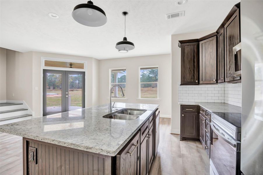 Kitchen view through to the breakfast area and back porch. Love that back yard view!