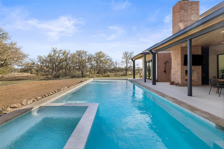 View of pool featuring a patio and a pool with connected hot tub