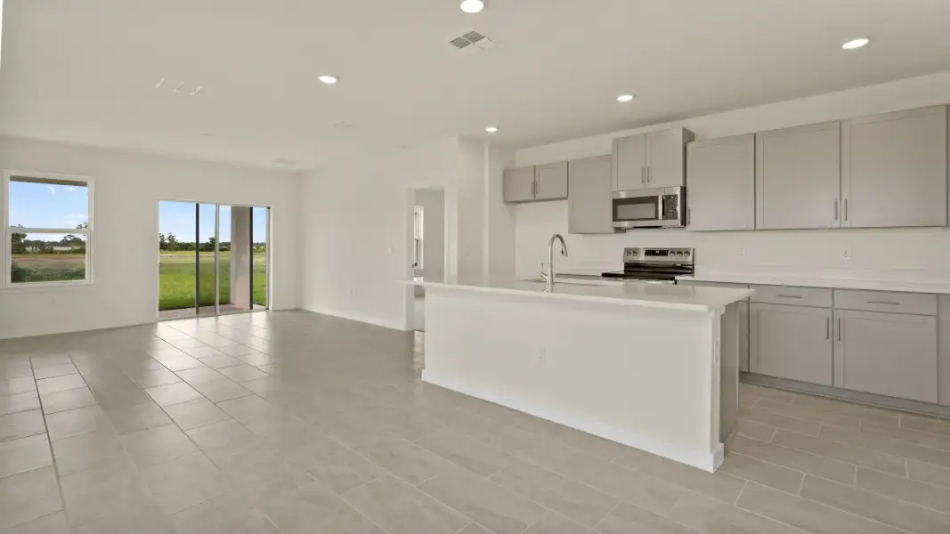 The Naples Living Room and Kitchen Island Quick Move-In Home at Willowbrook North by DRB Homes in Winter Haven, FL