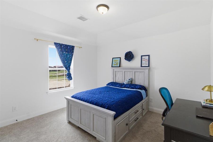 Bedroom featuring light gray carpet flooring, white walls, and a single window with a white frame