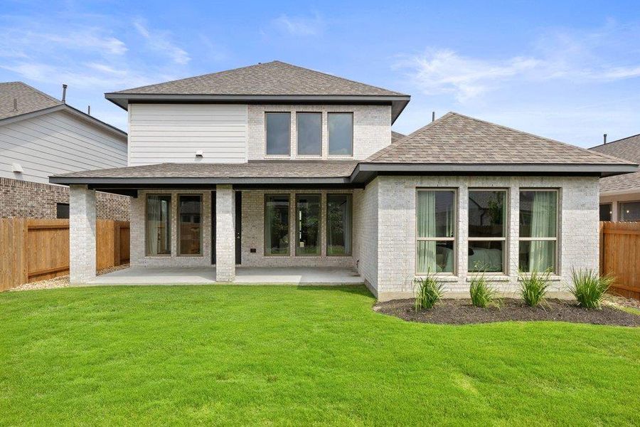 A pristine backyard with a generous lawn and a covered patio for outdoor enjoyment.