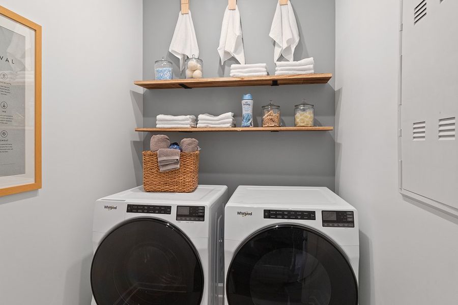 A white laundry room with a shelf and a white laundry basket. A white laundry room with a shelf and a white laundry basket.