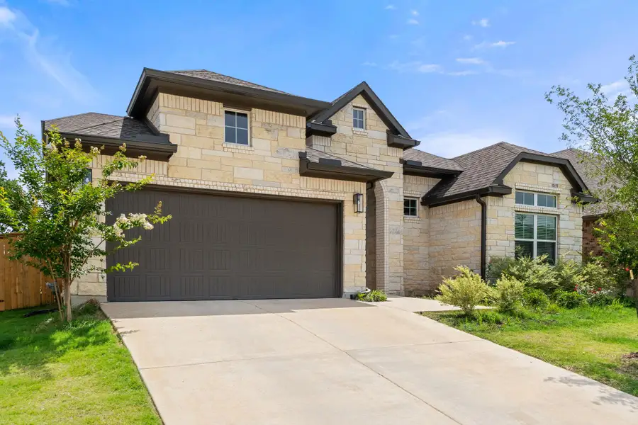 French country home with stone siding, driveway, and a shingled roof French country home with stone siding, driveway, and a shingled roof