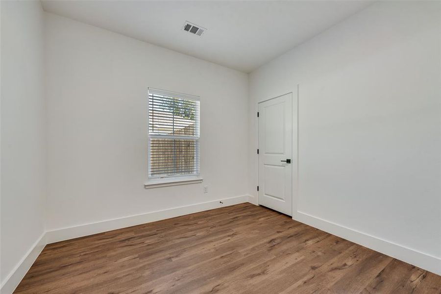 Empty room featuring wood finished floors and baseboards Empty room featuring wood finished floors and baseboards
