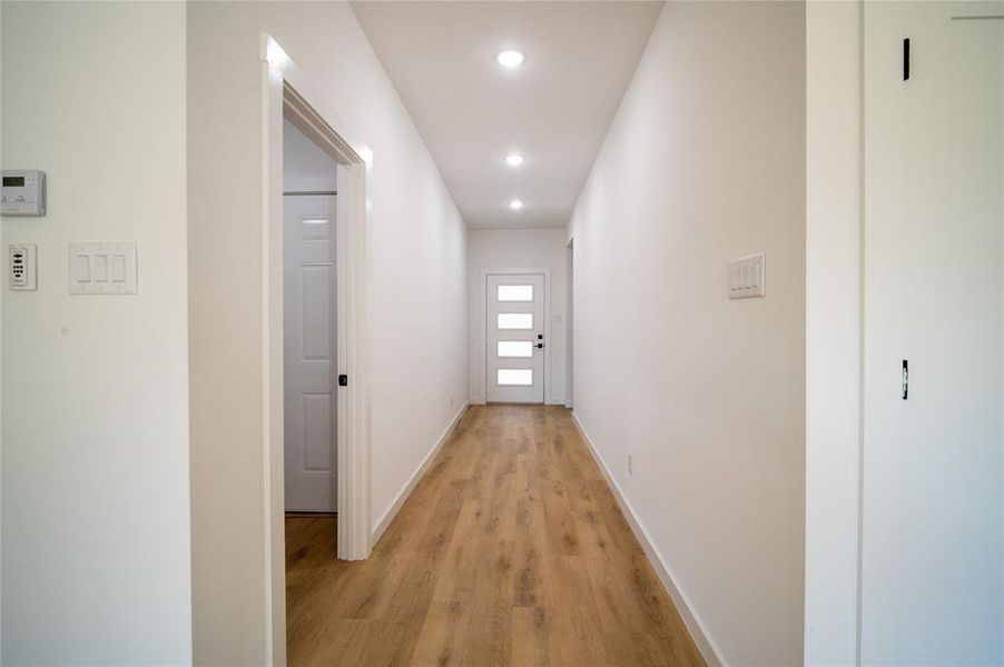 Corridor with light hardwood / wood-style flooring