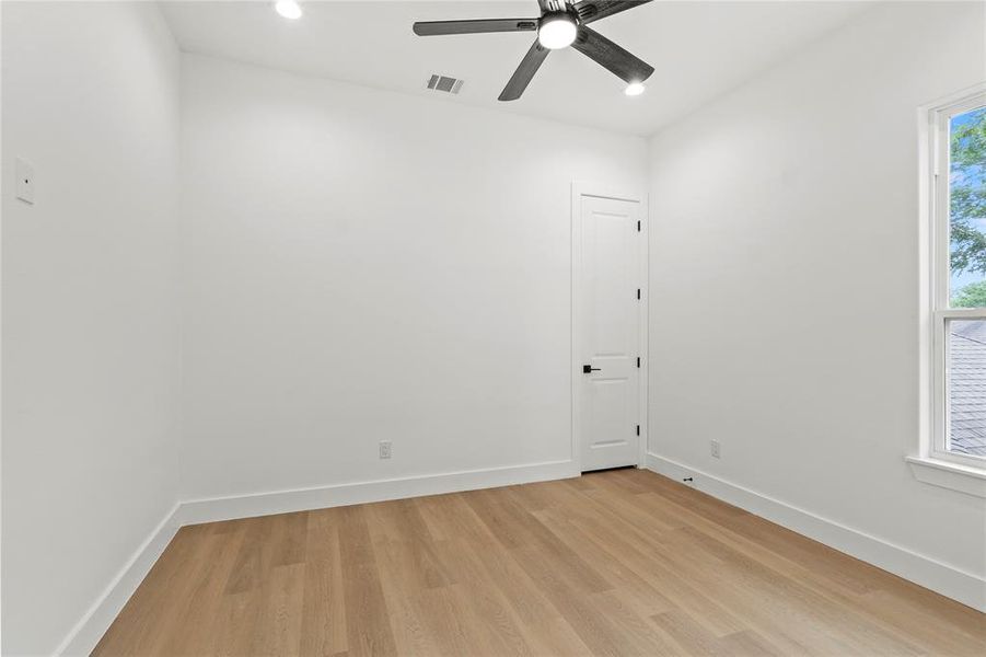 Unfurnished room with baseboards, a ceiling fan, visible vents, and light wood-type flooring